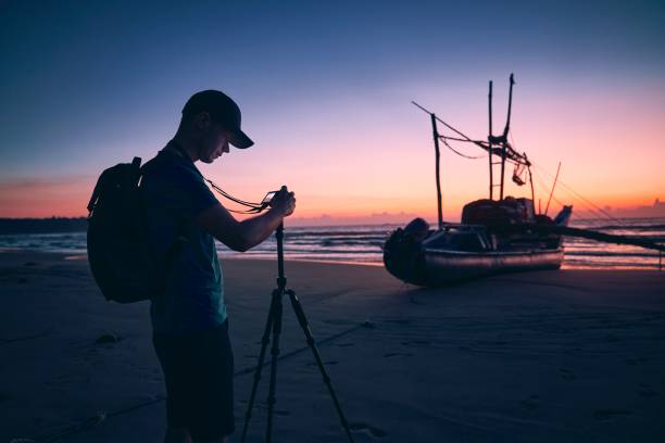 istock Photographer on beach at beautiful sunrise 1198027876