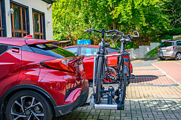 Parked car with a bike carrier attached to the stern. Bansin, Germany - September 14, 2019: Parked car with a bike carrier attached to the stern and two bicycles mounted on it. bicycle rack photos stock pictures, royalty-free photos & images