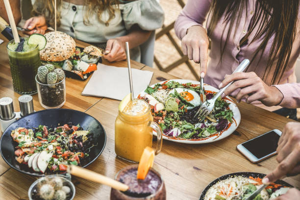 handsicht der jungen leute, die brunch essen und smoothies schale mit ökologischen strohhalmen in kunststofffreiem restaurant - gesunder lebensstil, food-trends konzept - fokus auf top-gabelschale - child eating healthy eating healthy lifestyle stock-fotos und bilder