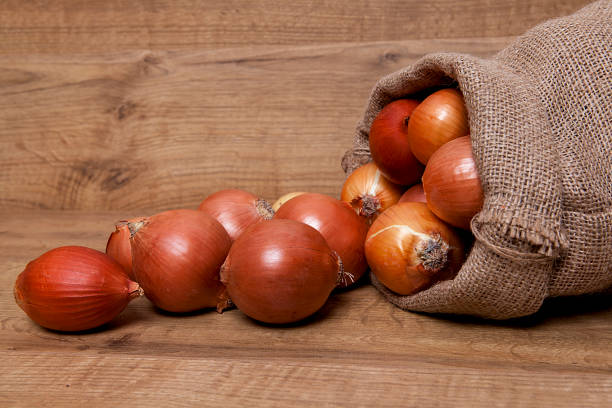 istock Yellow onion on wooden background. 1198032888