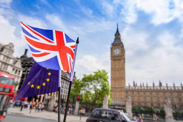 bandera europea ondeando junto a la unión británica jack frente a las cámaras del parlamento, westminster, londres. - brexit fotografías e imágenes de stock