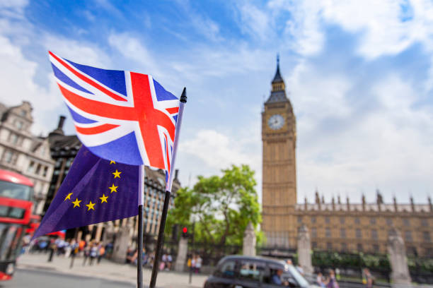 European flag flying alongside the British Union Jack in front of the Houses of parliament, Westminster, London. stock photo