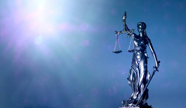 istock lady justice or justitia - blindfolded figurine holding balance scales - Panoamic image wih copy space. 1198035502