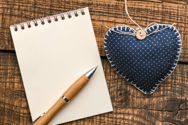 istock Empty notebook, pen and heart on a wooden table. Top view, concept on Valentine`s day. Empty space in the notebook to enter text or graphics. 1198035568