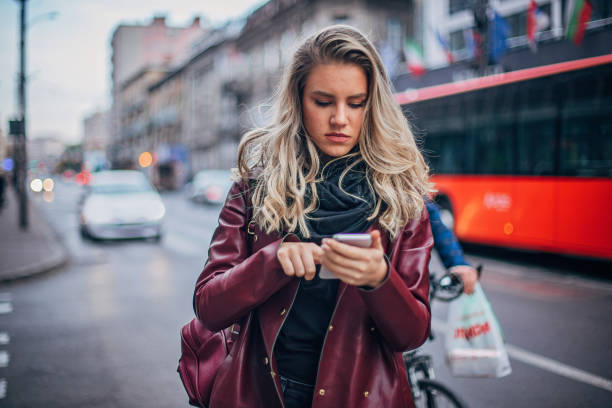 istock Pretty young woman is text messaging 1198036245