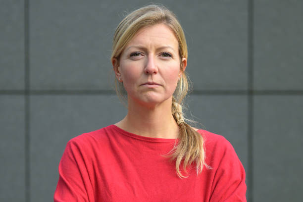 istock Blond woman in red shirt with arms folded 1198037681