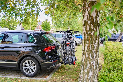 Bansin, Germany - September 14, 2019: Parked car with a bike carrier attached to the stern and two bicycles mounted on it.