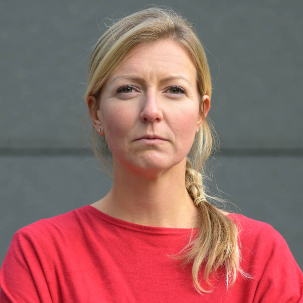 istock Blond woman in red shirt with arms folded 1198038535