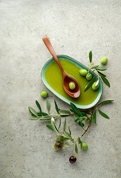huile d'olive aux olives et feuilles - olive verte photos et images de collection