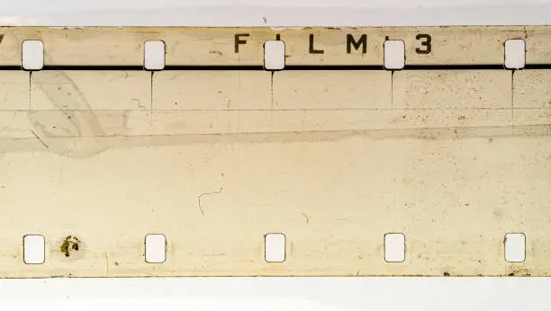Photo of Real and original 16mm film material on white background, empty 16mm filmstrip