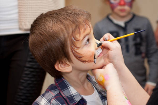 istock Little boy with painted face as lion 1198042536
