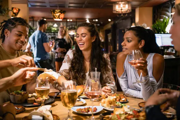 A mixed age range group of friends having a meal together at a restaurant.