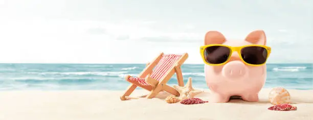 Photo of Piggy bank on vacation. Finance and travel concept