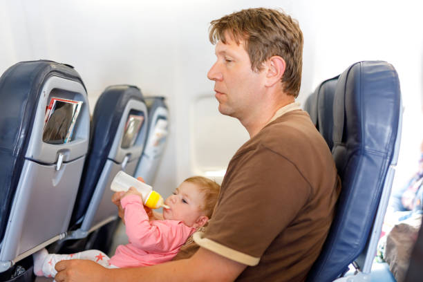 istock Father holding his baby daughter during flight on airplane going on vacations 1198045437