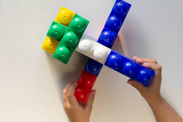 istock Child hand playing with multicolor blocks and made toy on the white background 1198047729
