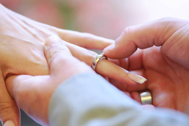 istock bride and groom Wedding ring exchange, straight marriage concept 1198047764