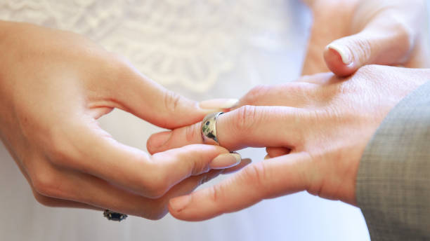 istock bride and groom Wedding ring exchange, straight marriage concept 1198047929