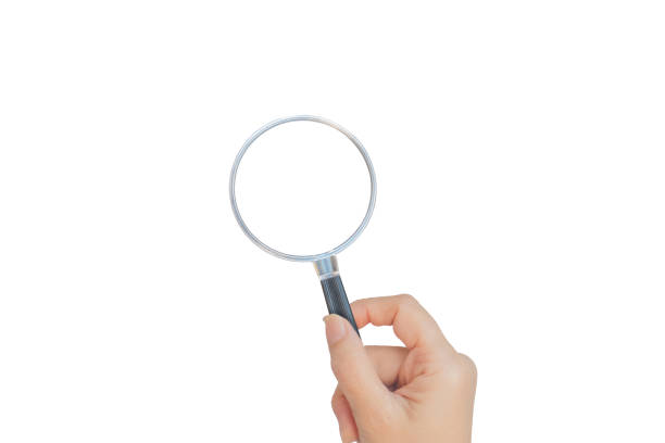 istock Female hand holding black magnifying glass isolated on white background. 1198049218