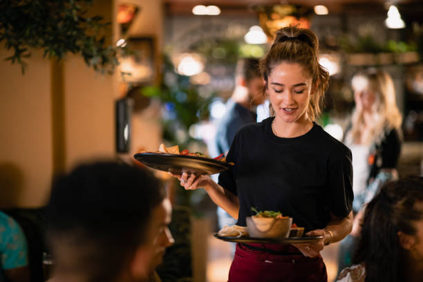 Who Ordered This Main? A waitress serving customers food at a restaurant in Newcastle-Upon-Tyne. waitress stock pictures, royalty-free photos & images