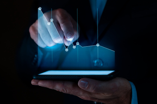 Close up shot of male hand and digital tablet with stock market graph