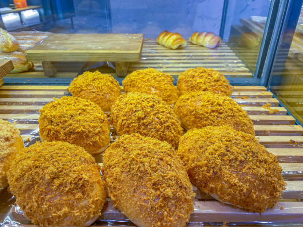 Golden chicken floss bun in showcase at pastry shop Pile of meat floss bread on tray at pastry shop deli pie stock pictures, royalty-free photos & images