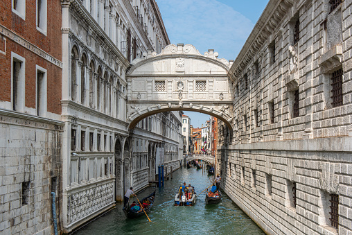 People touring in gondolas under the famous baroque style Bridge of Sighs at Venice city, Italy.