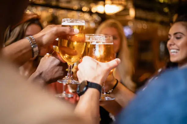 A group of friends having a celebratory toast together at a bar.