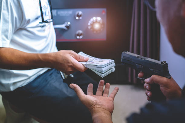 assaltante armado usando a arma para roubo. - currency crime gun conflict - fotografias e filmes do acervo