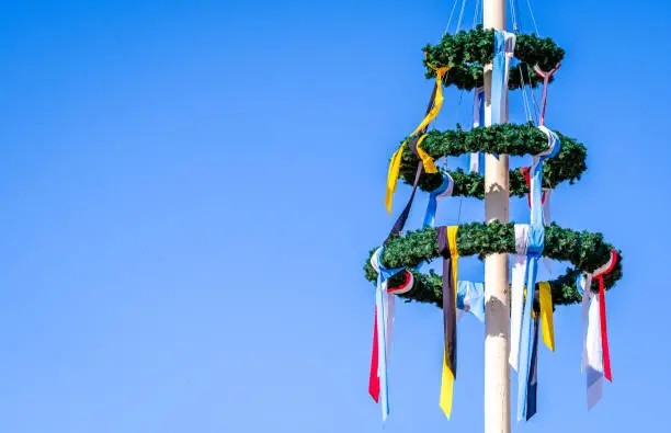 typical bavarian maypole in front of blue sky