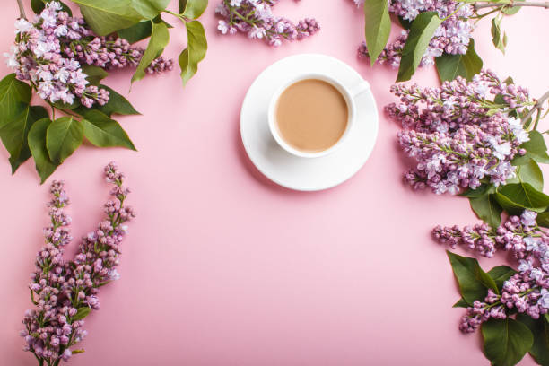 Purple lilac flowers and a cup of coffee on pastel pink background. Morninig, spring, fashion composition with copy space. Flat lay, top view. Purple lilac flowers and a cup of coffee on pastel pink background. Morninig, spring, fashion composition with copy space. Flat lay, top view. human representation photos stock pictures, royalty-free photos & images
