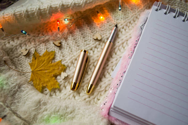 istock Notepad and autumn leaf on the knitted plaid. Winter flat lay. Hygge style. 1198054968