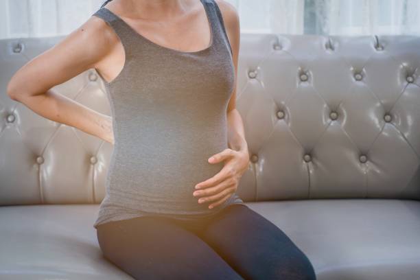 The Asian pregnant young woman having back pain. The backache sick. stock photo