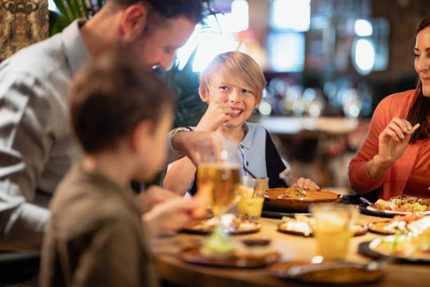 Fun Family Times A family having a meal together in a restaurant. kids restaurant pictures stock pictures, royalty-free photos & images