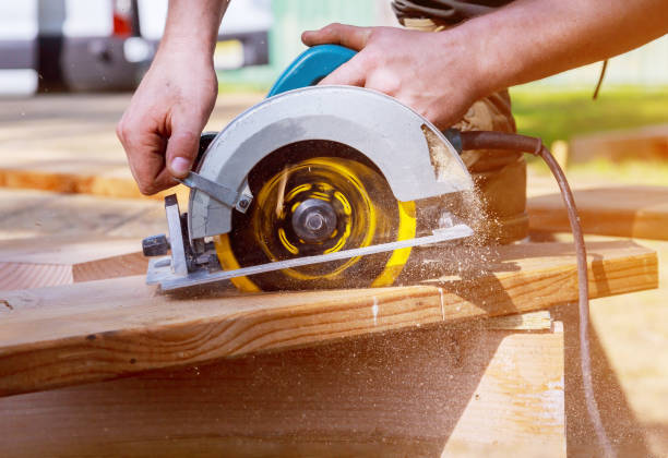 istock Builder saws a board with a circular saw cutting a wooden plank 1198059250
