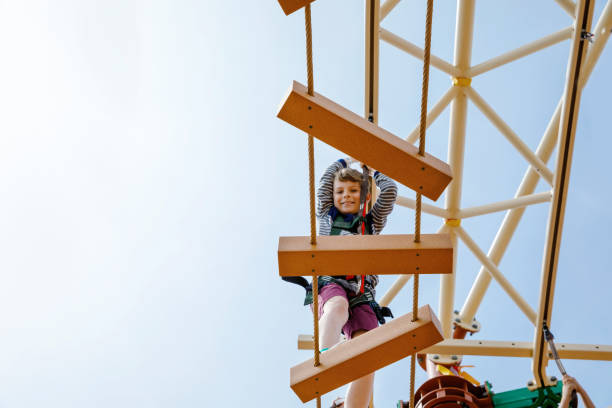 istock Happy little kid boy climbing on high rope course trail. Active child making adventure and action on family vacations. Challenge for brave kids. 1198059502