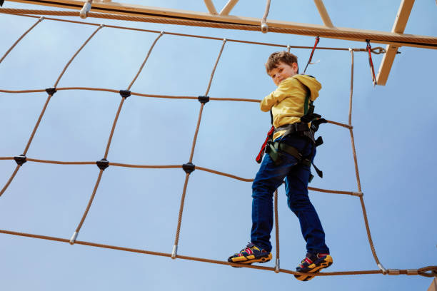 istock Happy little kid boy climbing on high rope course trail. Active child making adventure and action on family vacations. Challenge for brave kids. 1198060130
