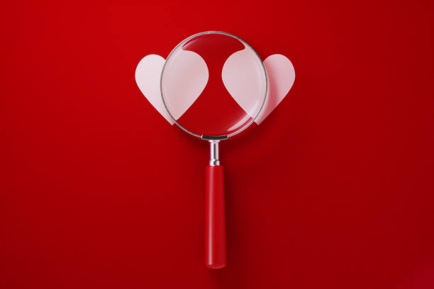 istock Magnifier and Heart Shapes Over Red Background 1198060213