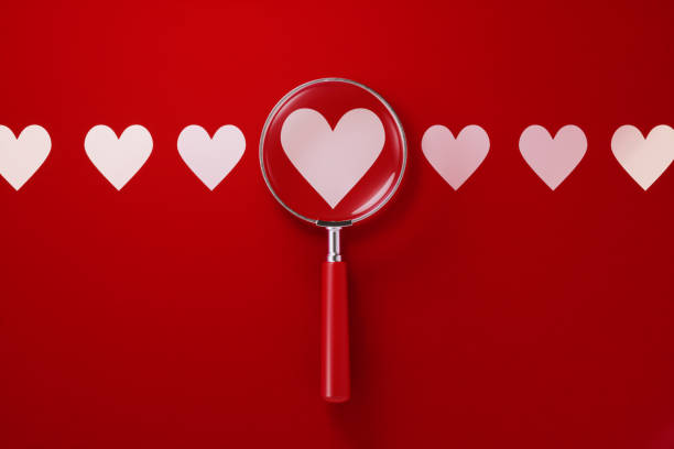 istock Magnifier and Heart Shapes Over Red Background 1198060354