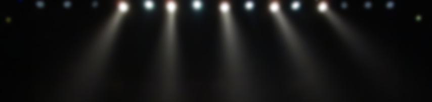 Blurry white stage spotlights with black background in darkness
