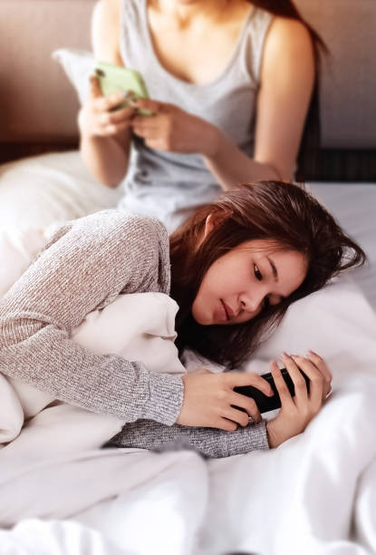 istock In selective focus of beautiful woman laying down on bed,using mobile phone ,blurry light around 1198062124