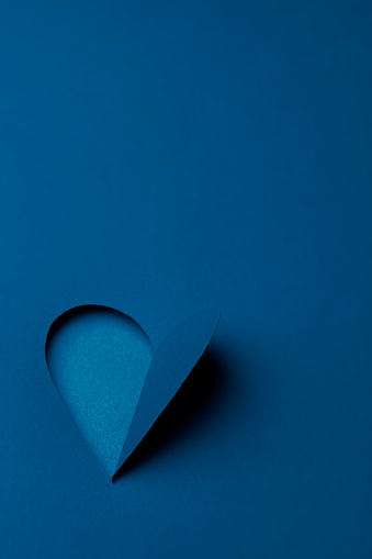 Holiday minimalist greeting card design. Classic blue color heart from paper Happy Valentines day. Romantic love concept background with copy space for text. Vertical orientation