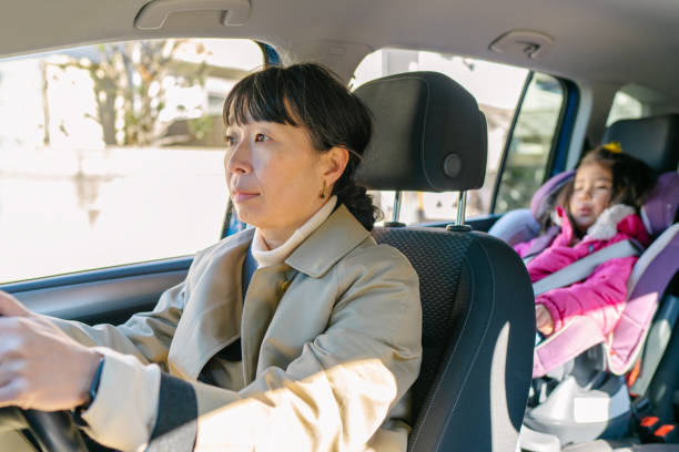 istock Working mother driving car her with daughter 1198064547