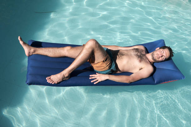 istock a handsome young men on swimwear resting on a Water mat 1198065705