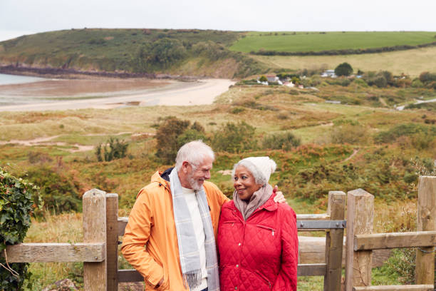 istock Loving Active Senior Couple Resting By Gate As They Walk Along Coastal Path In Winter 1198067426