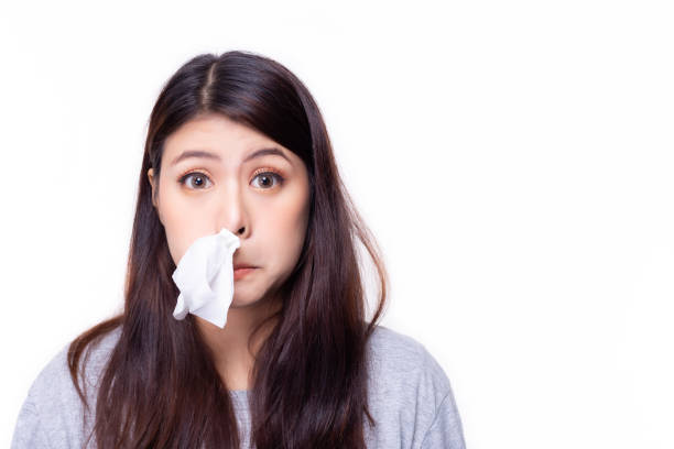 asian woman put tissue paper in her nose. she have a stuffed nose or runny nose. pretty girl has a cold or be allergic to weather. it's winter time or rainy season, hay fever is playing up. copy space - hay fever imagens e fotografias de stock
