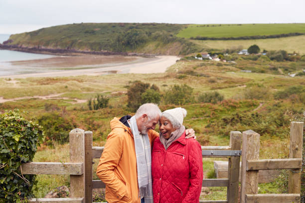 istock Loving Active Senior Couple Resting By Gate As They Walk Along Coastal Path In Winter 1198069547