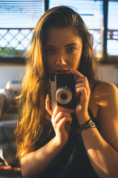 istock Girl is holding the camera towards the camera, looking at the camera 1198071969