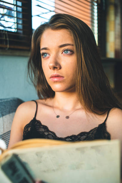 istock Girl reading book on the sofa 1198072170
