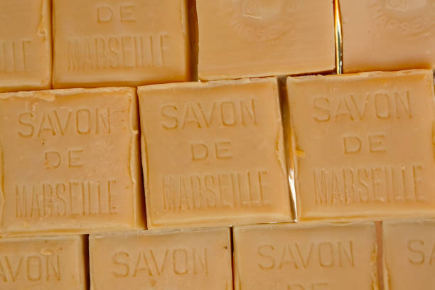 Savon de Marseille soap in the form of a cube Nice, France - May 18, 2014: Marseille soap also called Savon de Marseille, put up for sale at the market, traditional soap made from vegetable oils, under the same name produces for about 600 years. savon stock pictures, royalty-free photos & images