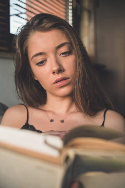 istock Girl reading book on the sofa 1198073800